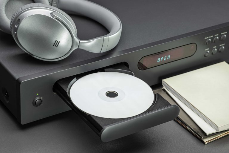 cd-player-headphones-listening-music-open-disc-tray-cd-envelopes-closeup